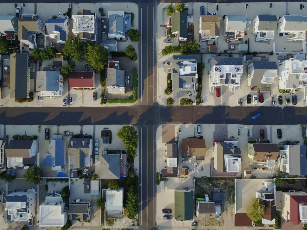 an aerial view of a residential area with a crossroad at its center.