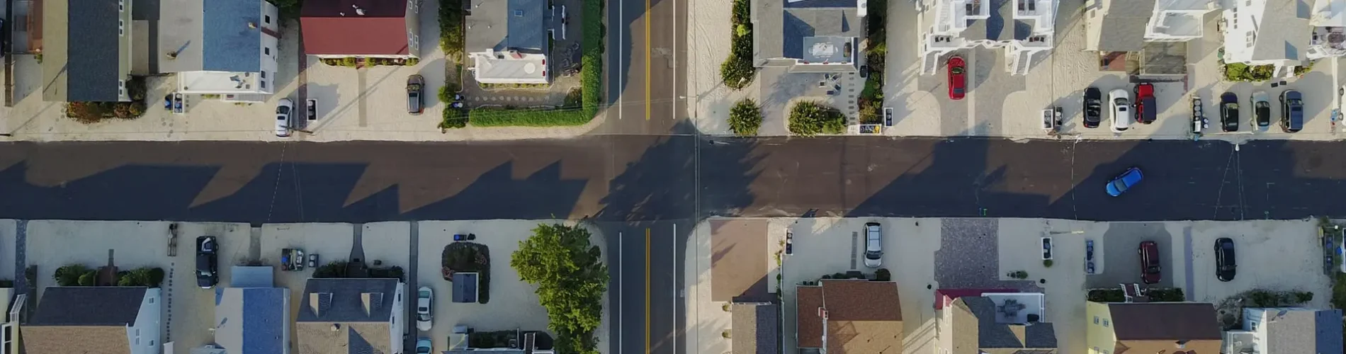 an aerial view of a residential area with a crossroad at its center.